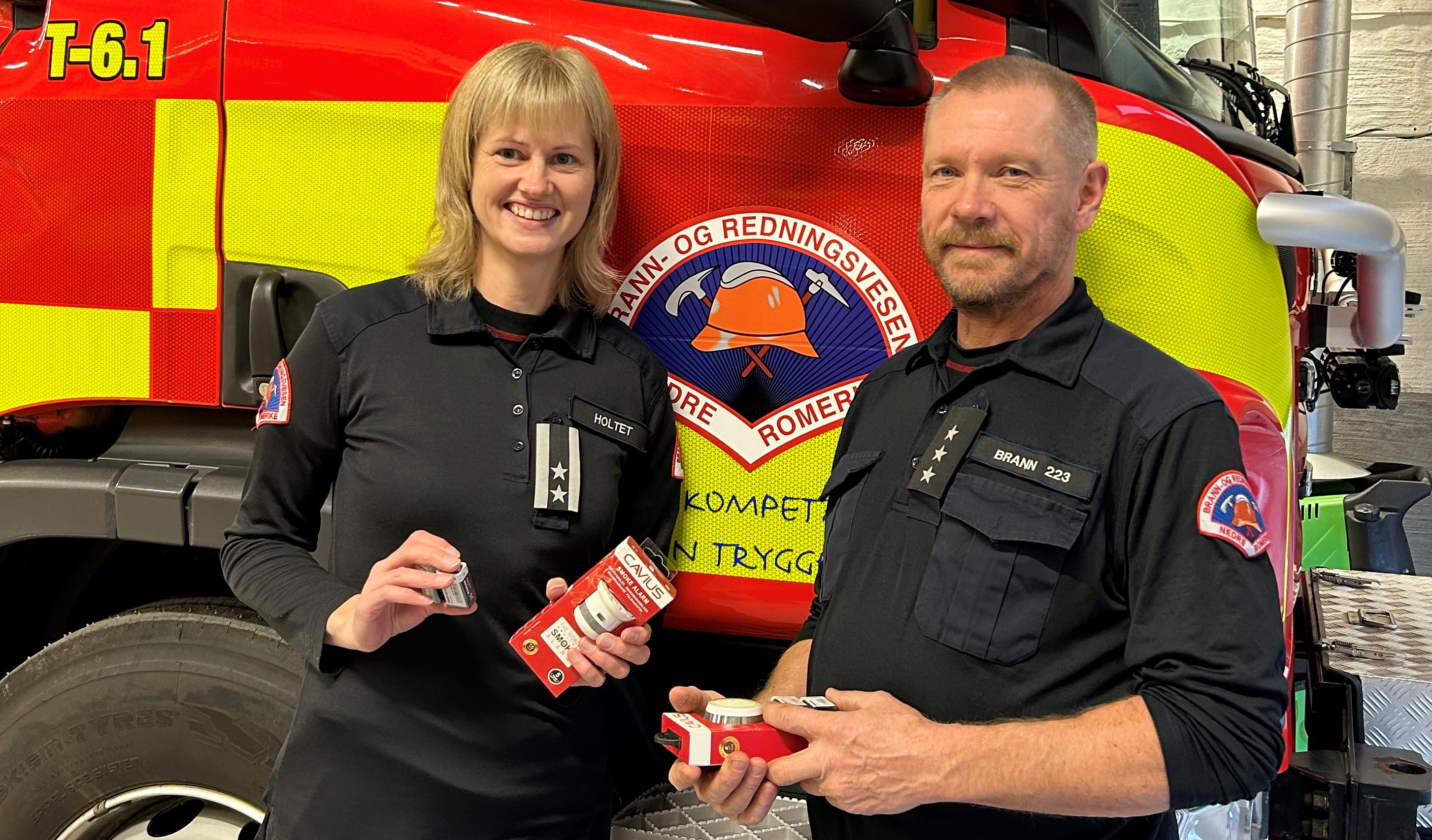 To fra brannvesenet som holder opp røykvarslere